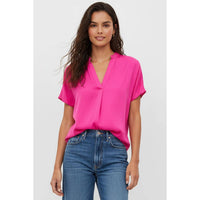 Bright pink short-sleeve V-neck Naked Zebra - Drop Shoulder Regular Blouse worn with blue jeans.