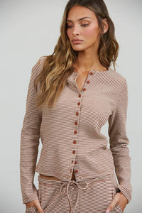A woman models the Creamon - CTP3592 BROWN Lounge Striped Button Down Top & Pants Set in Brown Stripe (available in S-M-L), featuring a brown and white striped long-sleeve button down top paired with matching wide-leg, drawstring waist pants. She stands against a plain background, one hand in her pocket.
