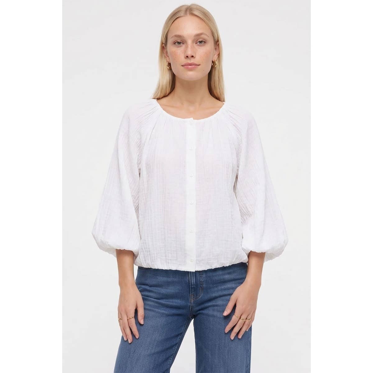 A woman wears a black Naked Zebra - Crinkle Texture Bubble Hem Button Up Blouse: Black / L with long balloon sleeves and a bubble hem, paired with blue jeans.